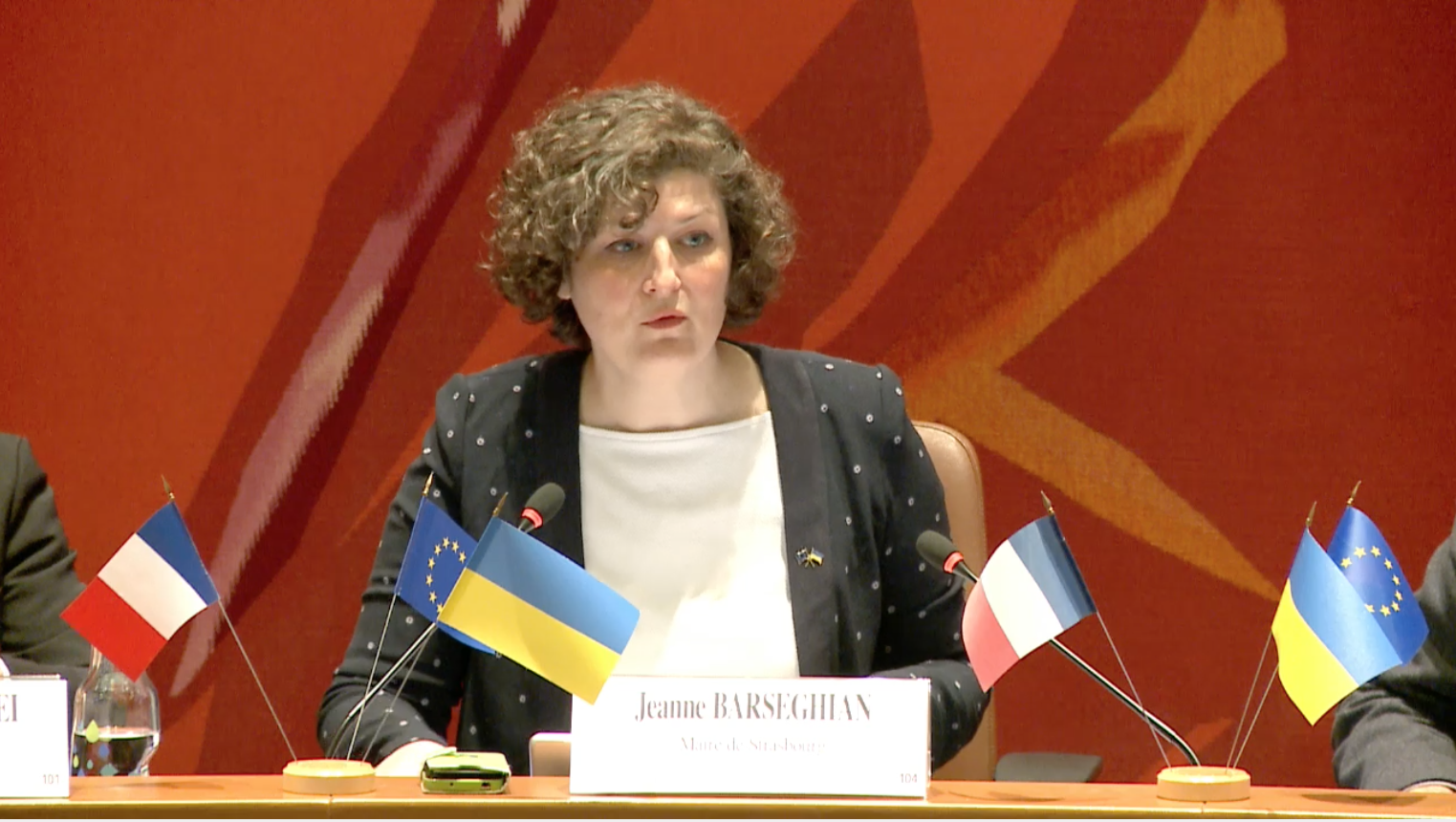 Jeanne Barseghian, avec devant des drapeaux ukrainiens, européens et français