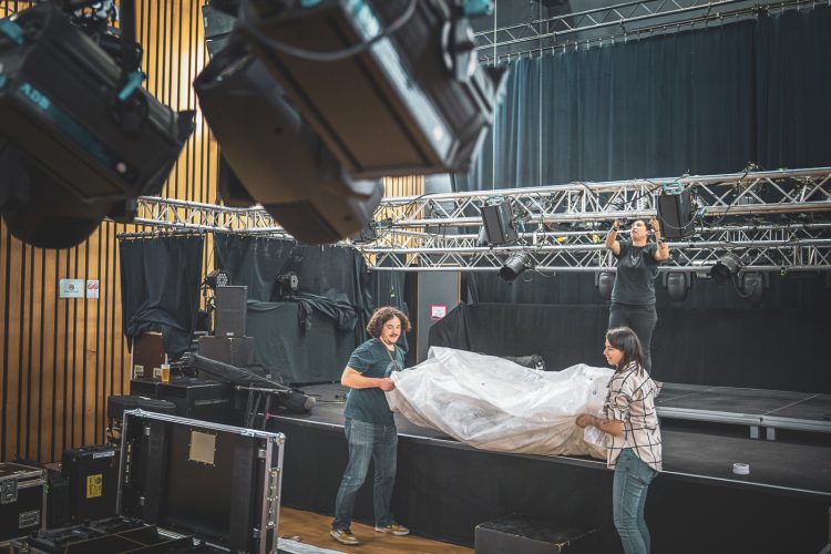 Espace Django 2025, coulisses, rangement, musiciens, techniciens, concert, salle, ambiance, montage