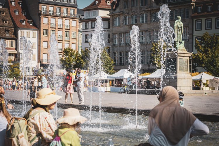 Famille devant fontaine place Kléber en été