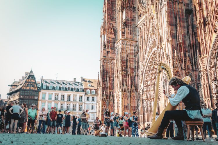 Musicien jouant harpe, place de la cathédrale Notre-Dame de Strasbourg en été