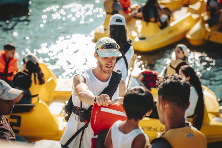 Homme distribuant gilet de sauvetage à la base nautique